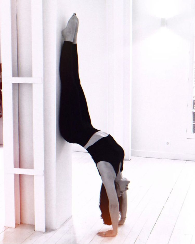 Position de yoga la tête en bas contre un mur pour illustrer les cours de yoga à la Ferme de Pontaly